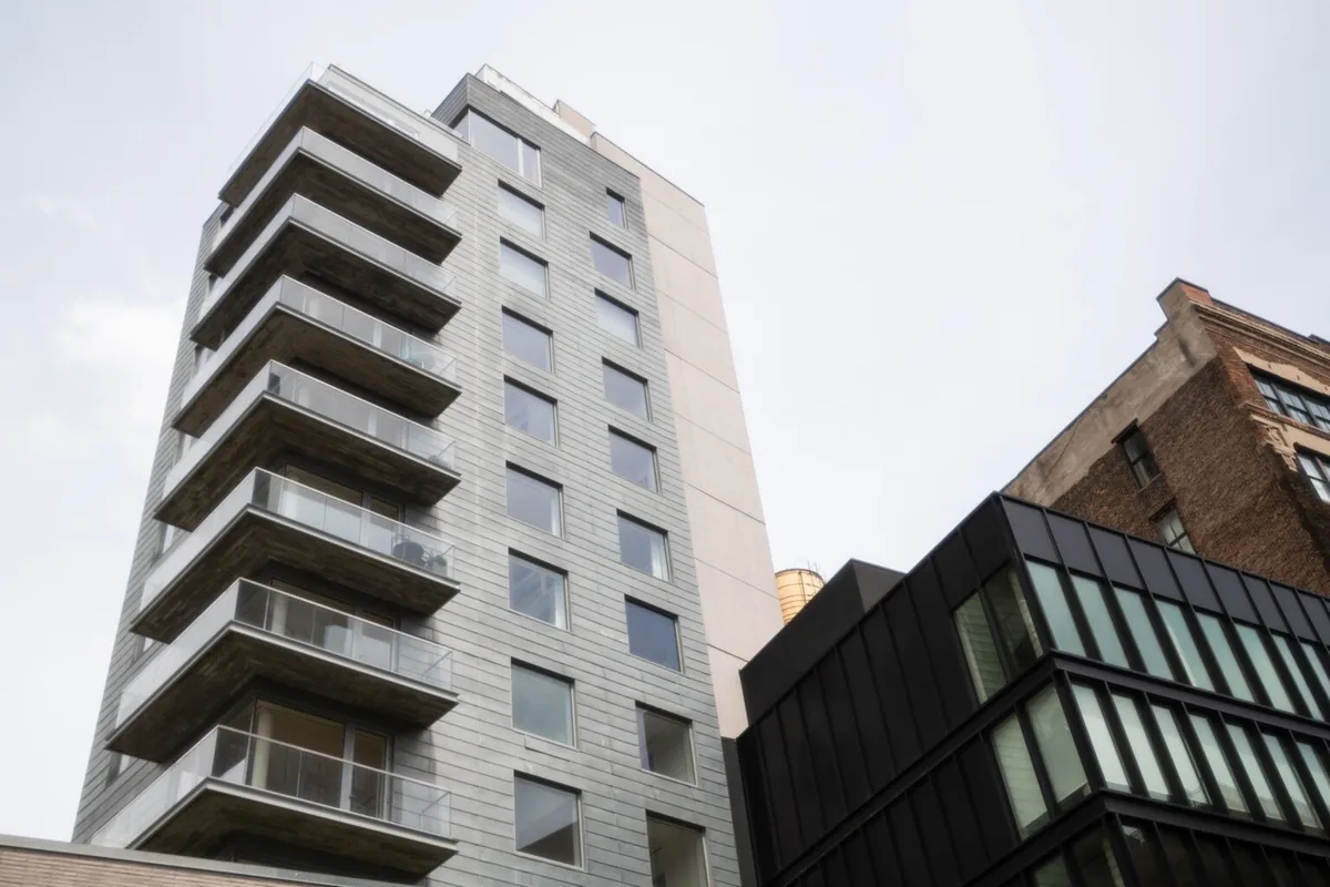Modern residential building with multiple balconies and large exterior windows