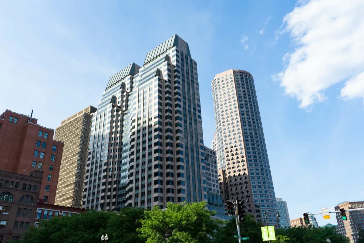 Modern high-rise residential buildings with reflective glass windows and blue sky