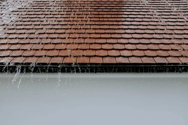 Frozen icicles hanging from roof gutter edge during winter weather