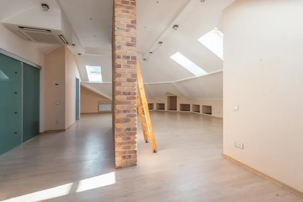 Interior attic space under construction with yellow ladder and brick support column