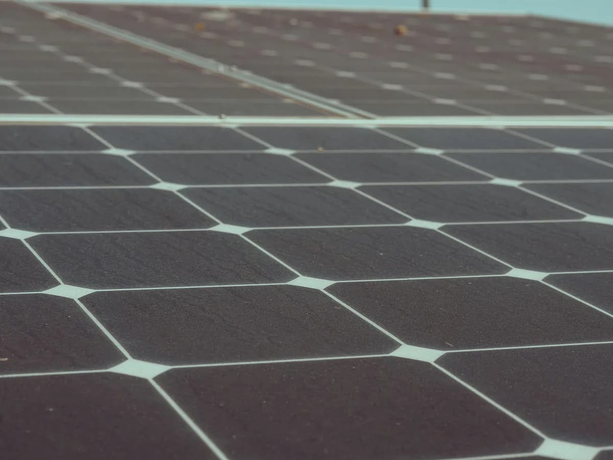 Close-up view of solar panel cells with light blue grid lines separating dark surfaces