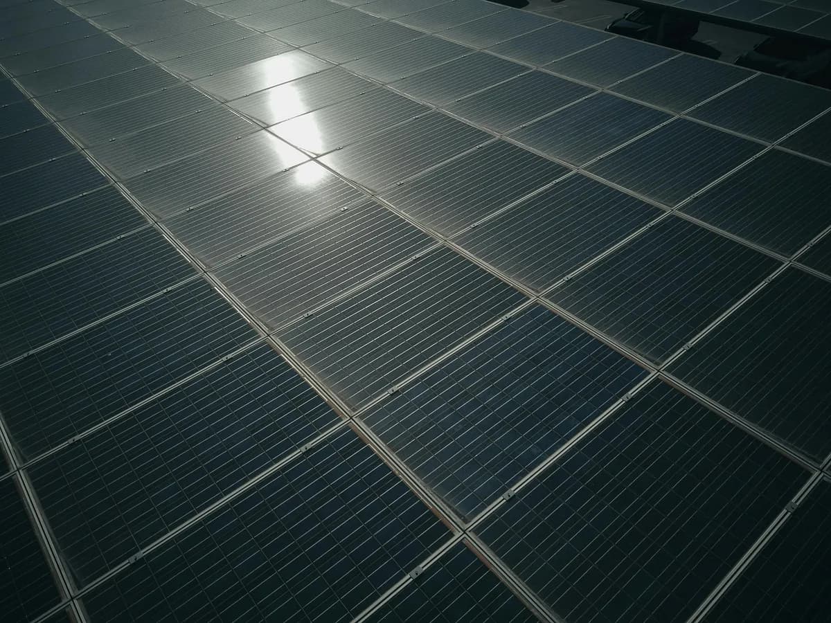 Grid of solar panels reflecting sunlight on residential rooftop installation