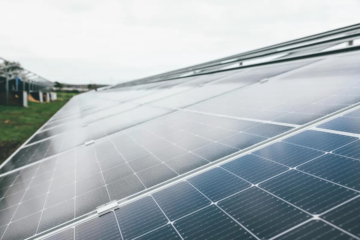 Solar panels on agricultural greenhouse with metal frame and white covering