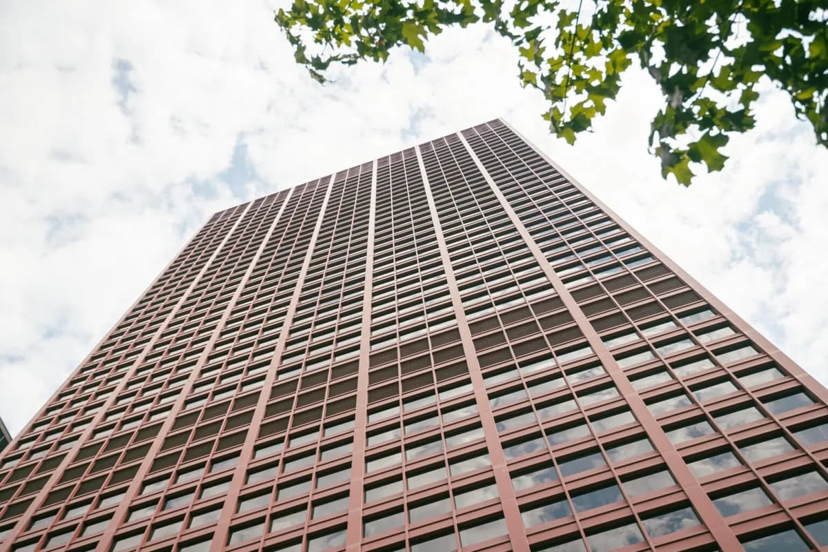 Tall residential skyscraper with repetitive window grid pattern and blue sky