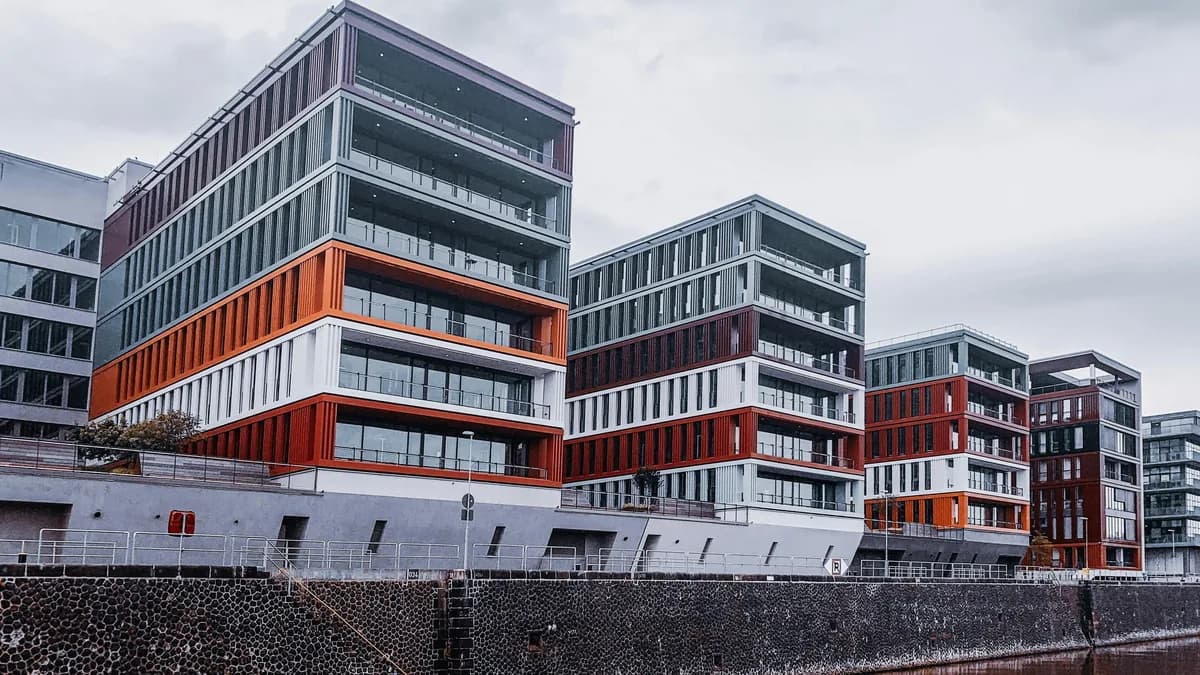 Modern waterfront residential buildings with colorful metal accents and glass windows