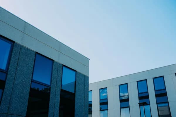 Modern commercial building exterior with large blue-tinted windows and clean glass panels