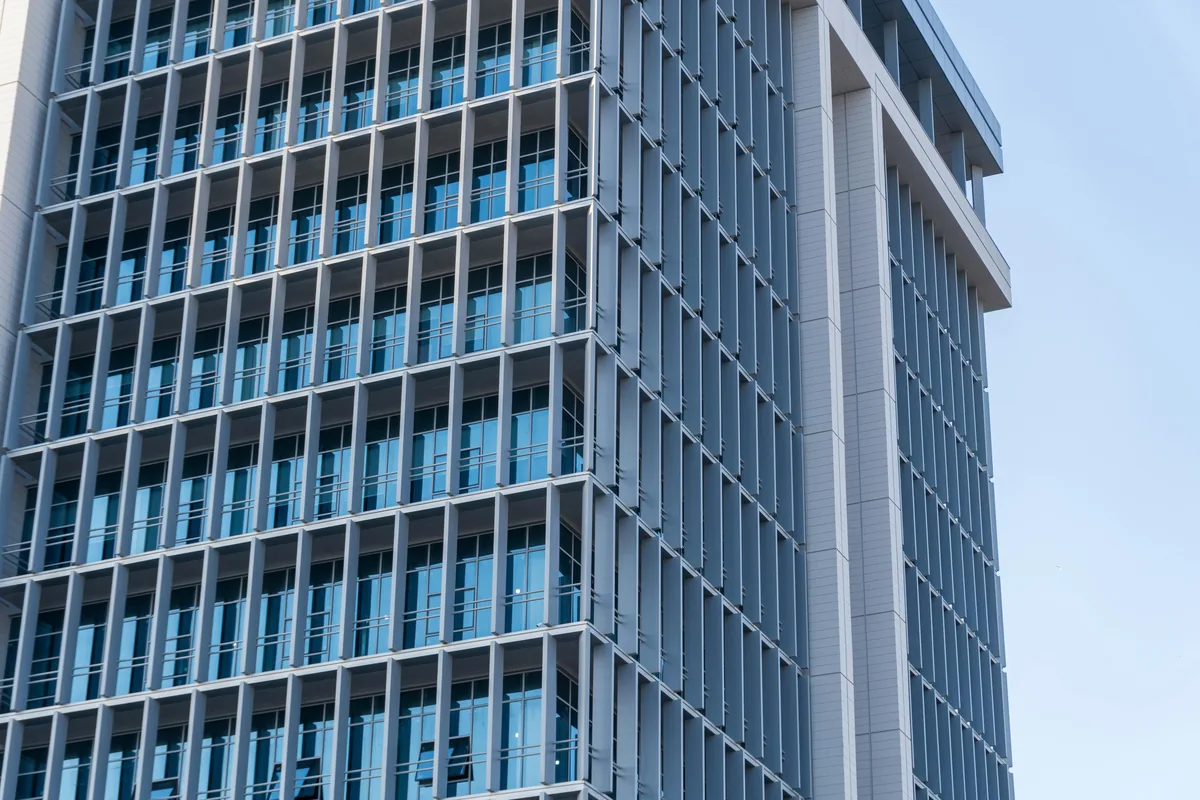 Modern high-rise building exterior with reflective glass windows and metal framework