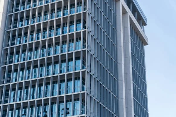 Modern high-rise building exterior with reflective glass windows and metal framework