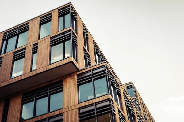 Modern multi-story building with large windows and wooden exterior cladding