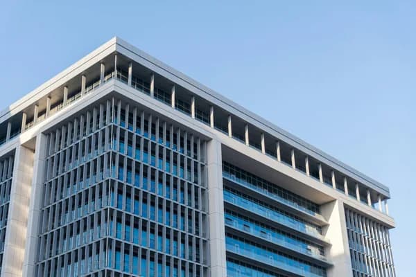 Modern office building exterior with blue-tinted glass windows and clean facade