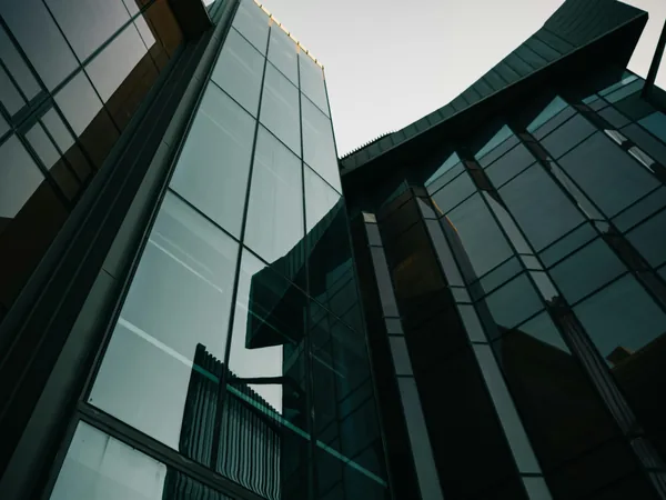 Modern glass building exterior with reflective windows and architectural details