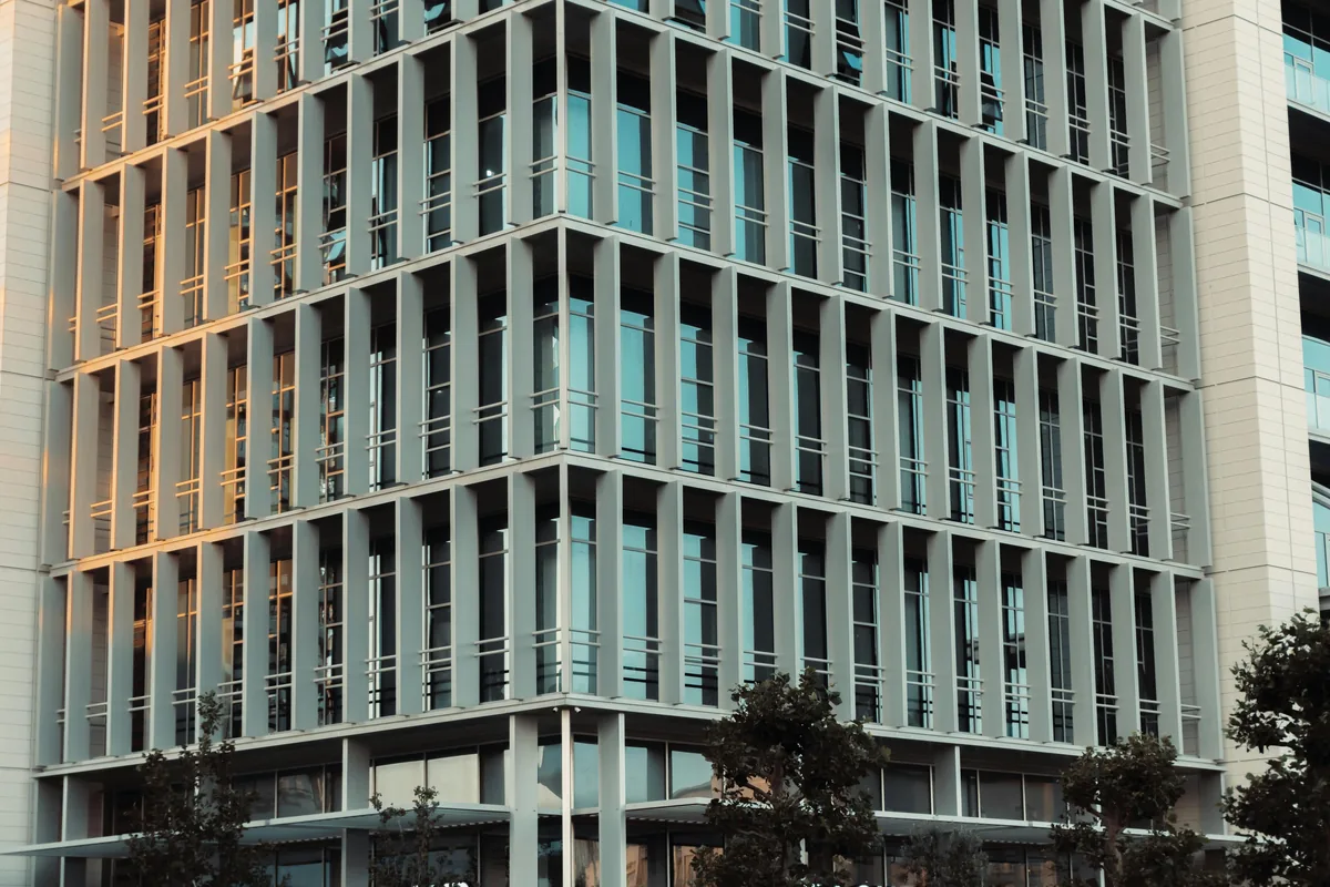 Modern glass and metal facade building with numerous windows requiring professional cleaning