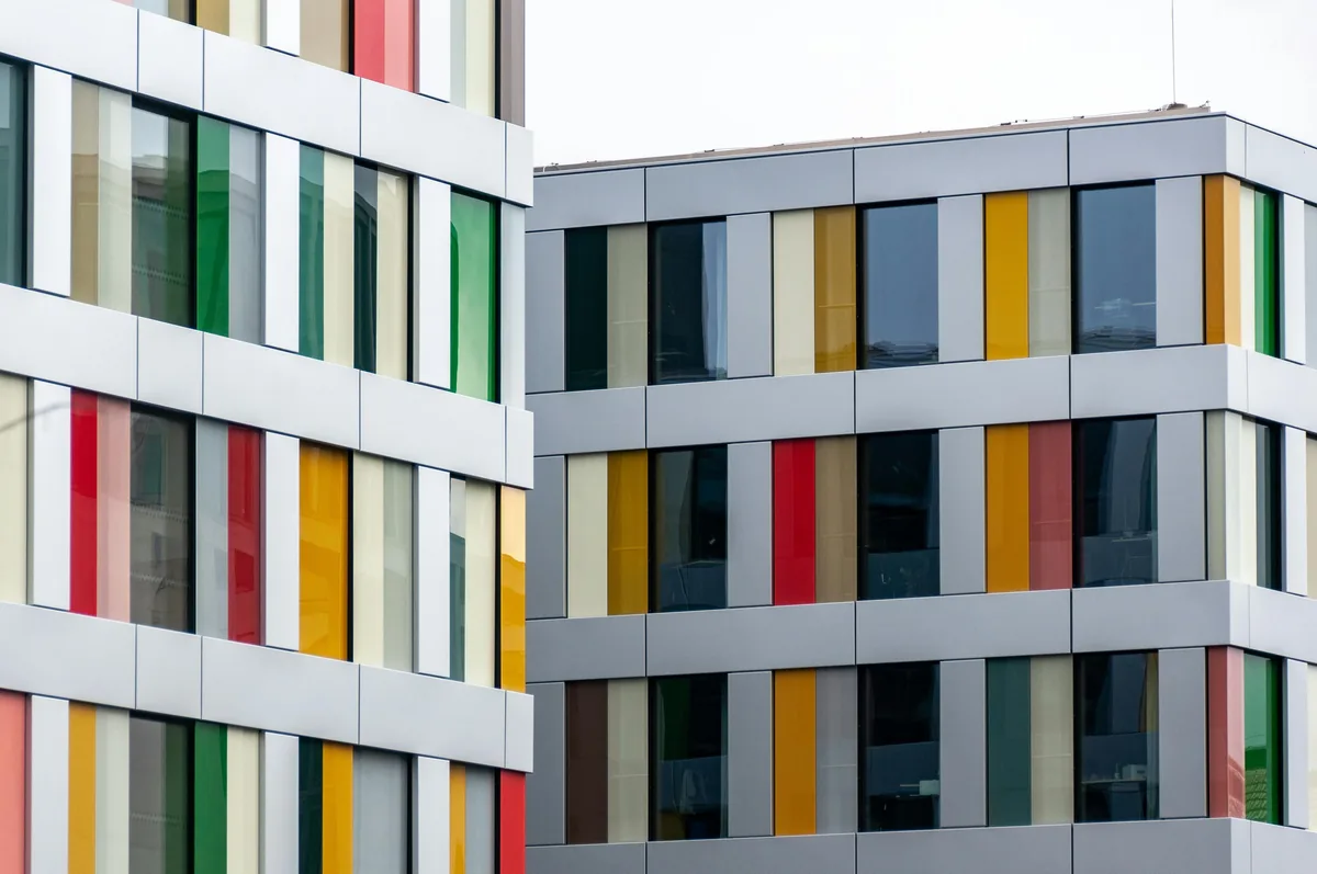 Modern apartment building with colorful window frames and clean glass exterior