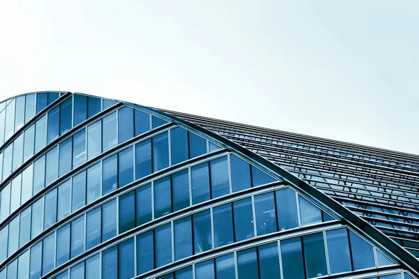 Modern glass curtain wall building exterior with multiple rows of reflective windows