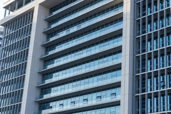 Modern commercial building facade with multiple glass windows and horizontal bands