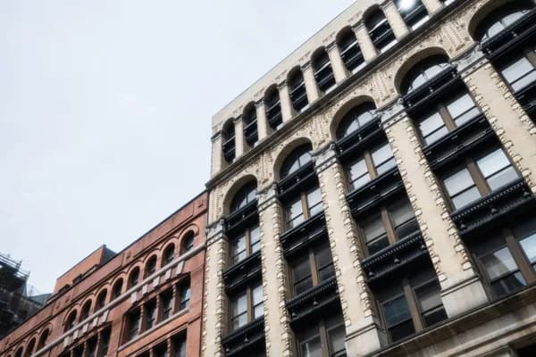 Historic brick and stone building facades with multiple rows of arched windows