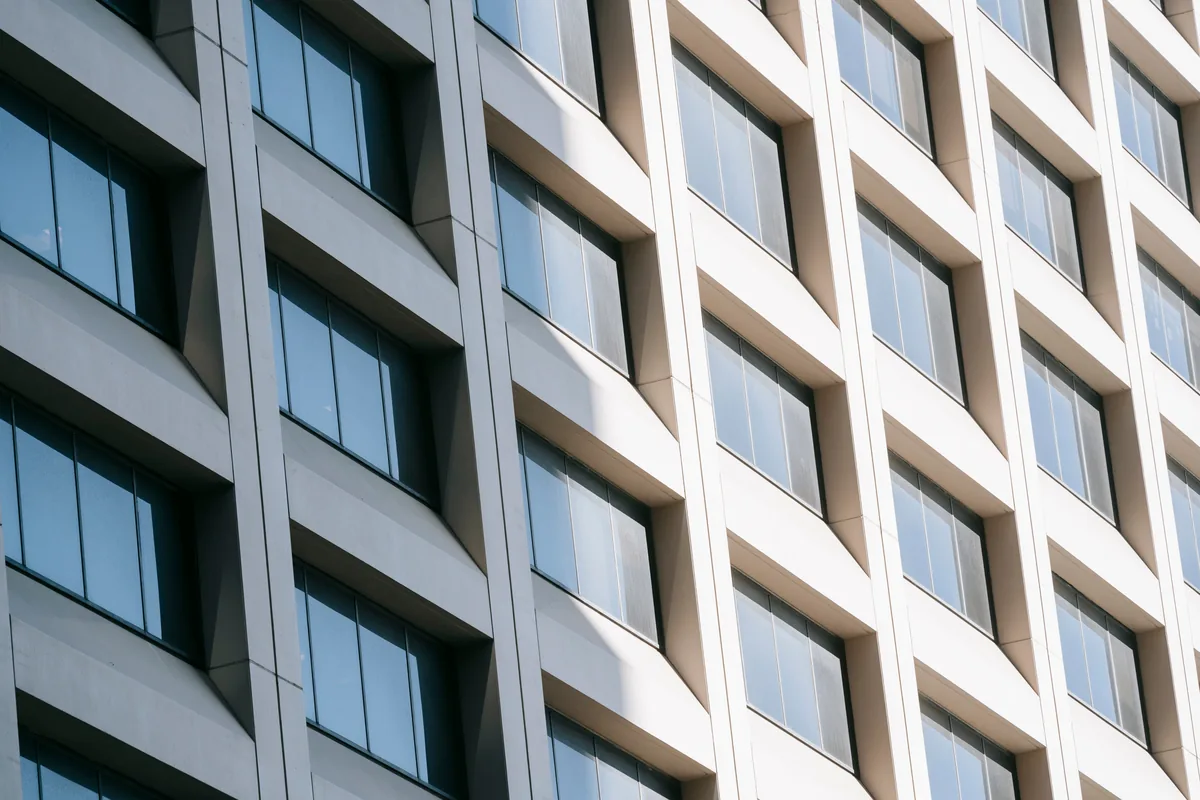 Modern office building facade with rows of clean windows and concrete panels