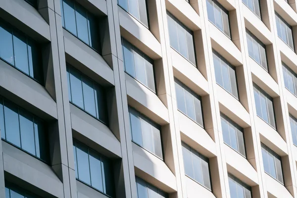 Modern office building facade with rows of clean windows and concrete panels