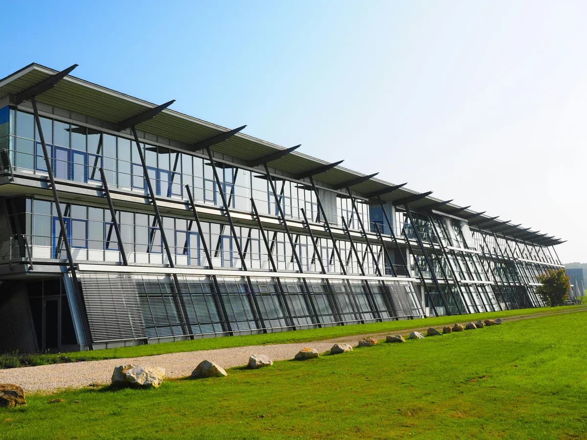 Modern glass and steel building facade with large windows and geometric bracing