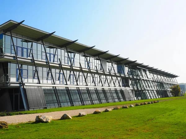 Modern glass and steel building facade with large windows and geometric bracing