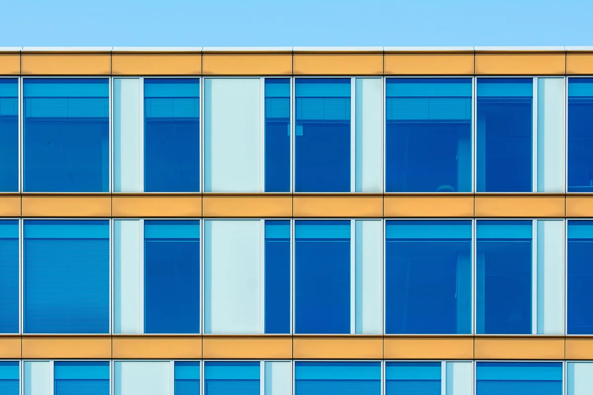 Modern office building facade with rows of large blue-tinted windows