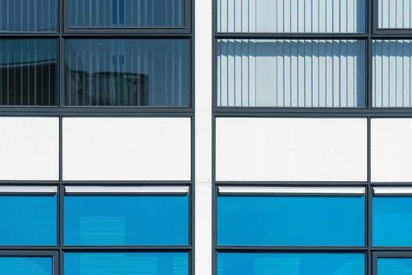 Modern building facade with reflective glass windows and blue panels
