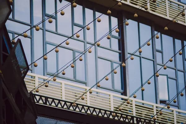 Modern building facade with large windows and decorative hanging brass spheres