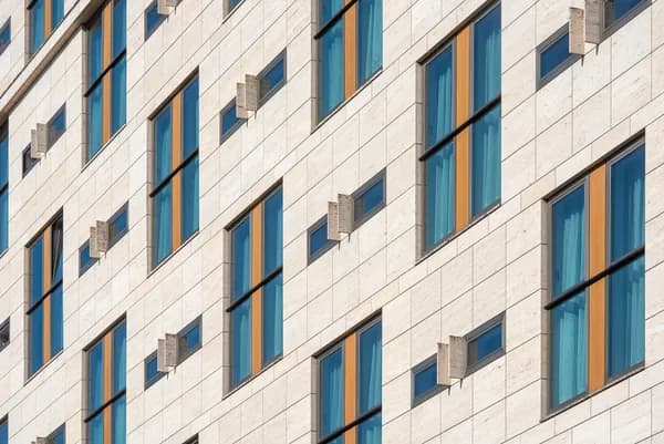 Modern office building facade with blue-tinted windows and vertical architectural elements