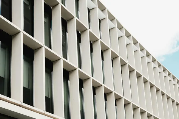 Modern office building exterior with rows of large windows and balconies
