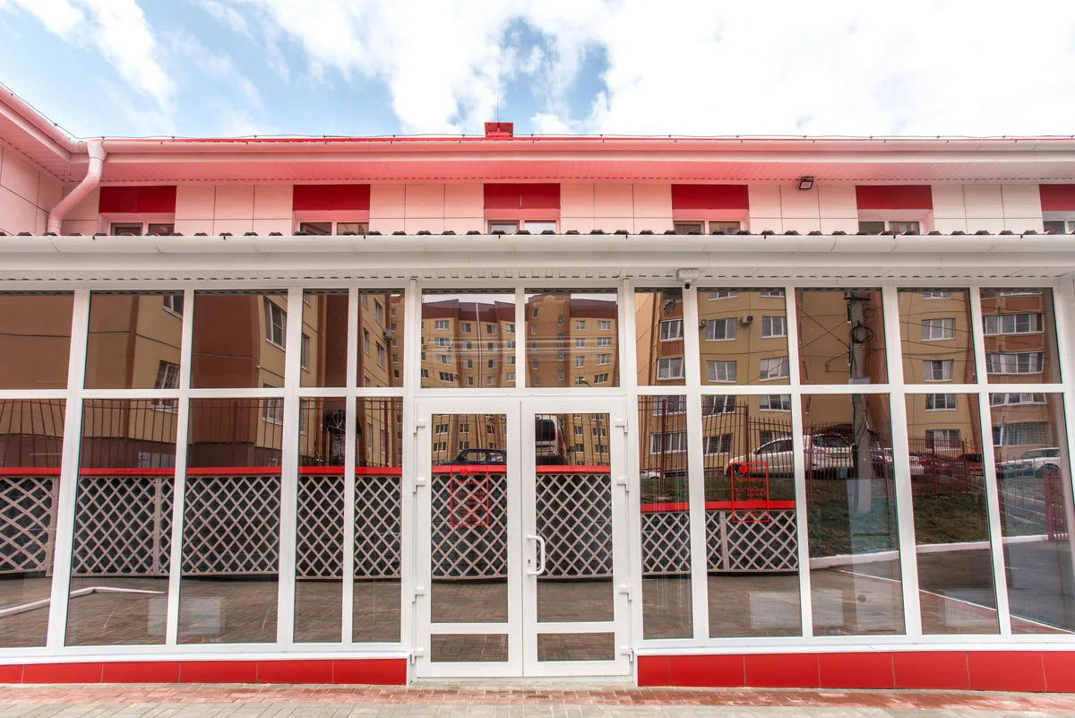 Large storefront with white-framed glass panels and red trim detailing