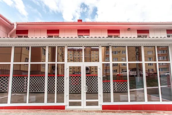Large storefront with white-framed glass panels and red trim detailing