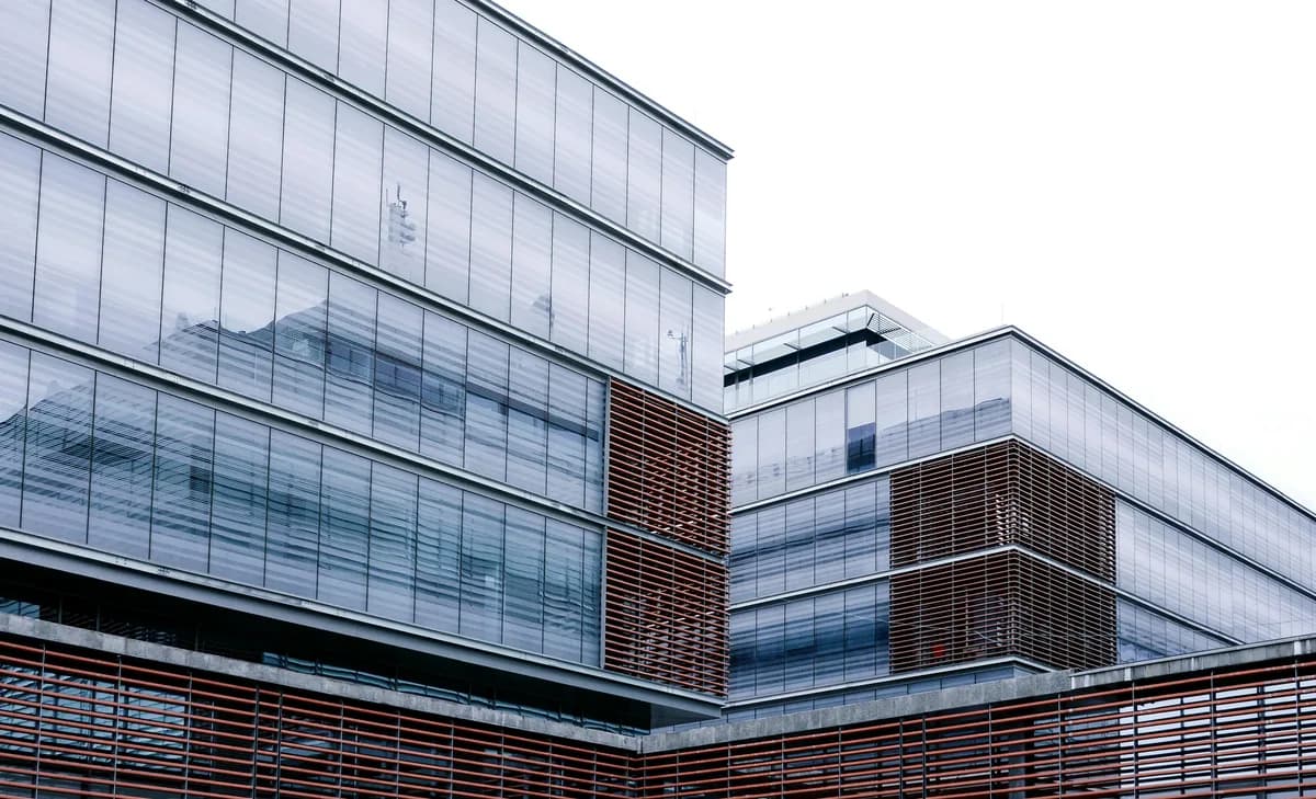 Modern building exterior with extensive glass windows and metal louvers