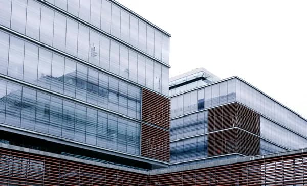Modern building exterior with extensive glass windows and metal louvers