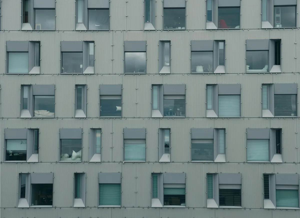 Modern residential building facade with rows of clean windows and white trim