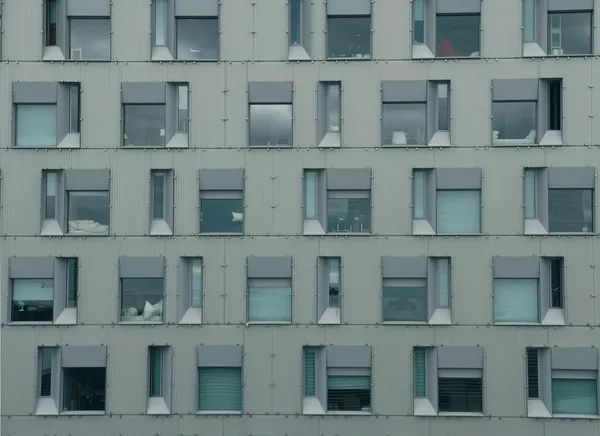 Modern residential building facade with rows of clean windows and white trim