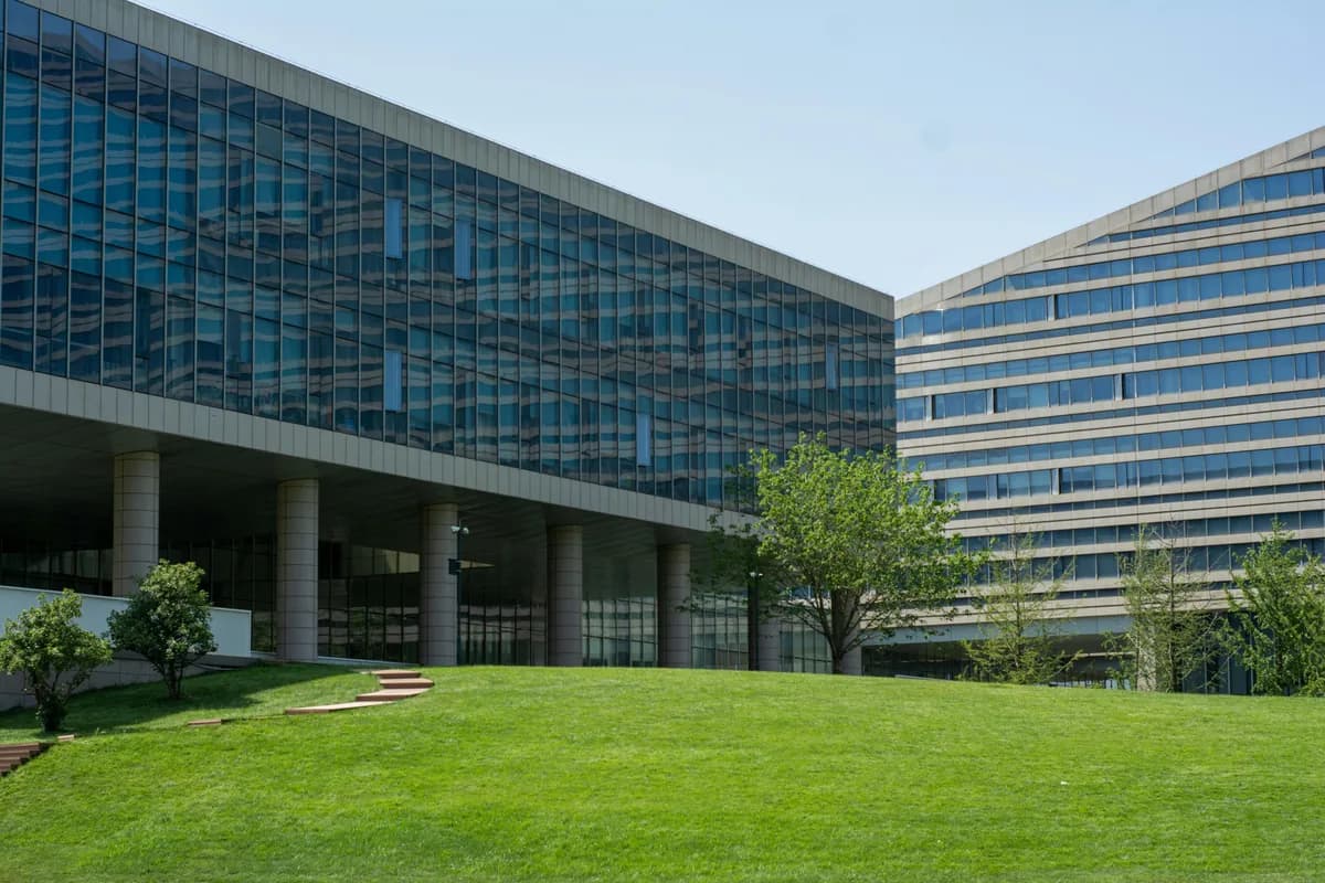 Modern glass office buildings with expansive windows and green courtyard