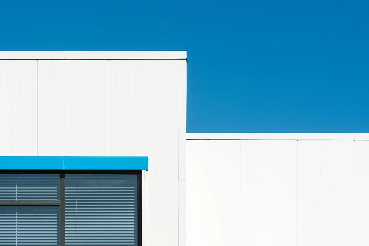 Modern building exterior with white panels and blue awning detail