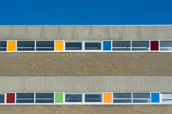 Modern building facade with colorful window panels and brick exterior