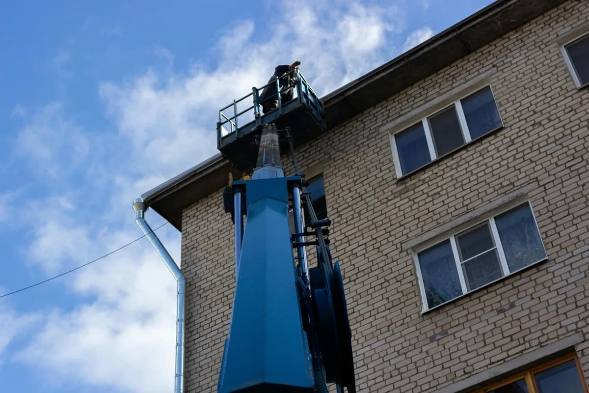 worker on elevated platform cleaning building exterior windows