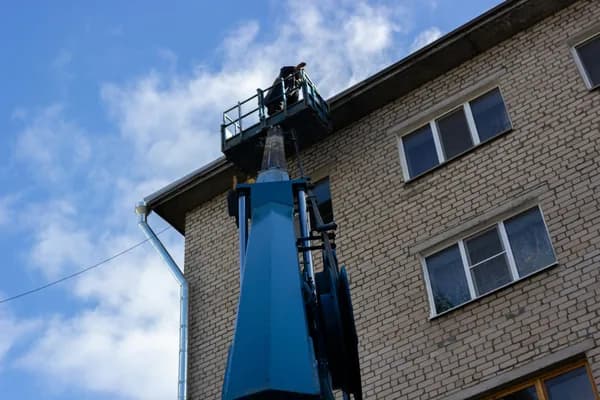 worker on elevated platform cleaning building exterior windows