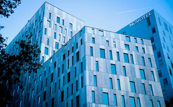 Modern multi-story office building with blue-tinted glass windows and metal cladding