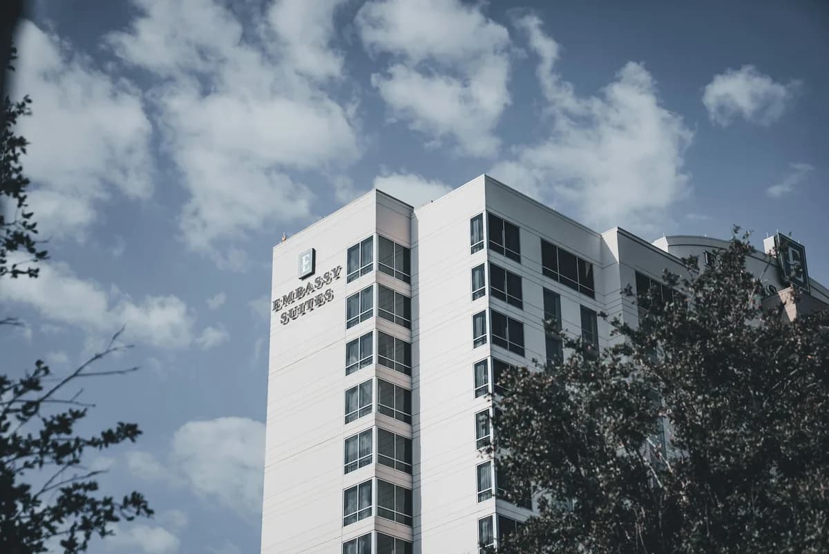 Modern white residential building with multiple rows of windows and balconies