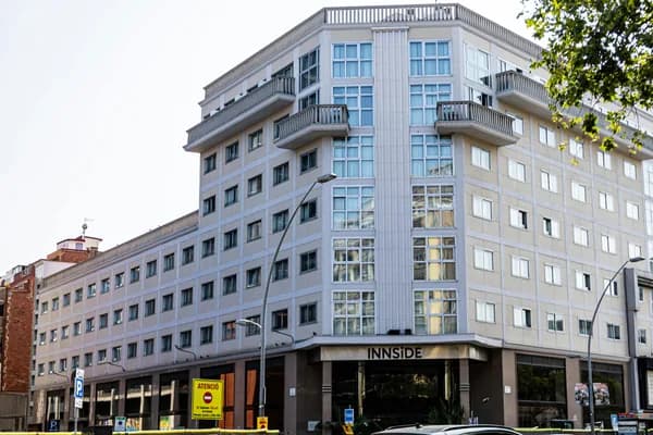 Modern multi-story residential building with numerous windows and balconies