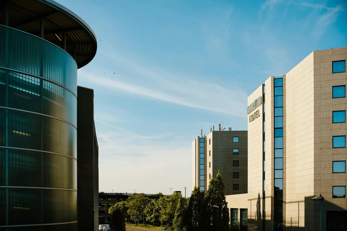 Modern multi-story buildings with glass windows and stone facades under clear sky