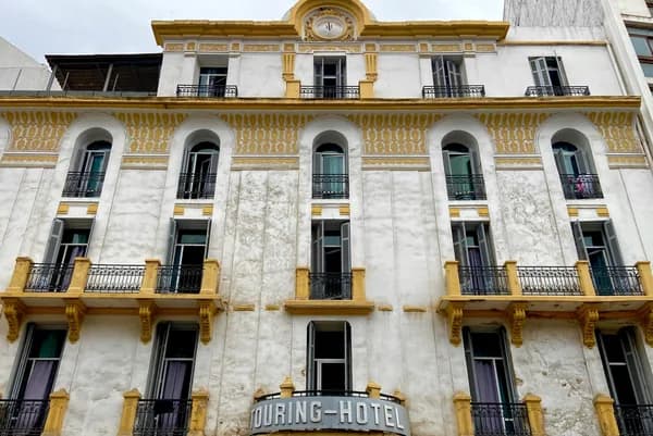 Historic multi-story building facade with arched windows and golden architectural details