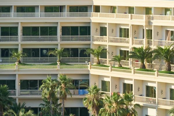 Multi-story residential building with numerous windows and ornate balconies