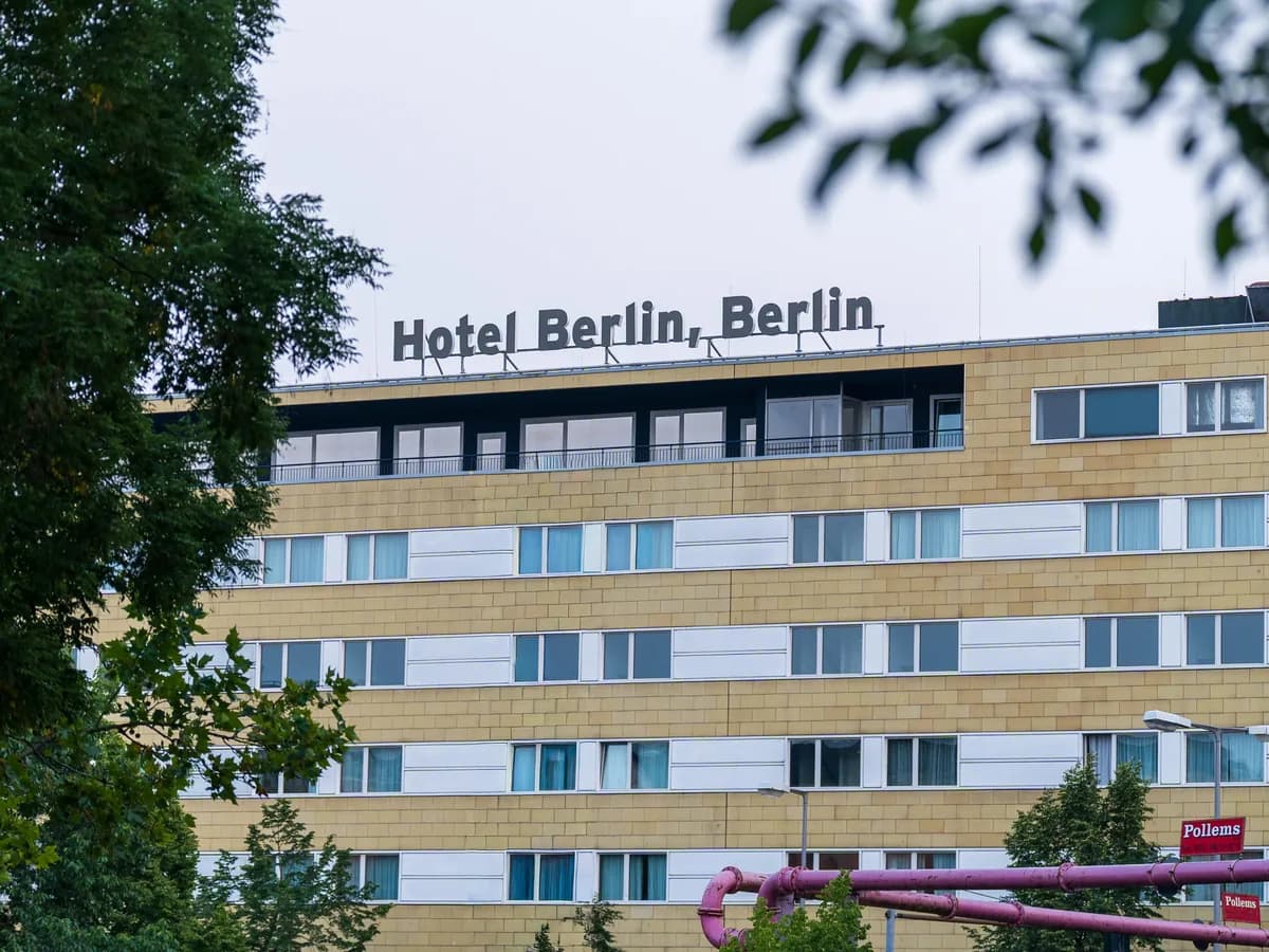 Modern multi-story building facade with rows of windows and horizontal white trim bands