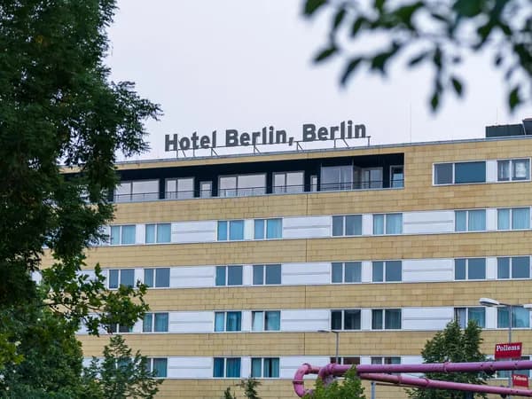 Modern multi-story building facade with rows of windows and horizontal white trim bands