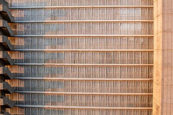 Modern high-rise building facade with repetitive metal and glass window pattern