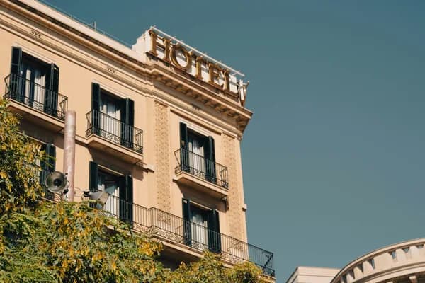 Historic cream-colored building facade with balconies and dark windows